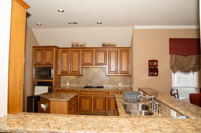 a kitchen with stainless steel appliances granite countertop a sink and cabinets