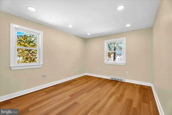 a view of empty room with window and wooden floor