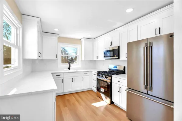 a kitchen with stainless steel appliances a refrigerator sink and microwave