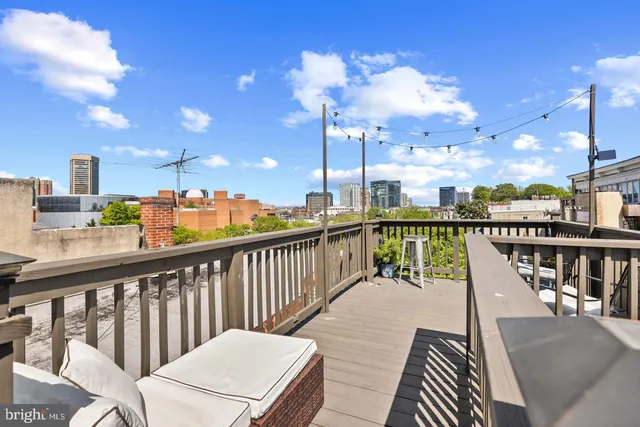 a view of a balcony with wooden chairs