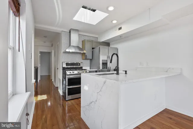 a kitchen with stainless steel appliances granite countertop a stove and a refrigerator