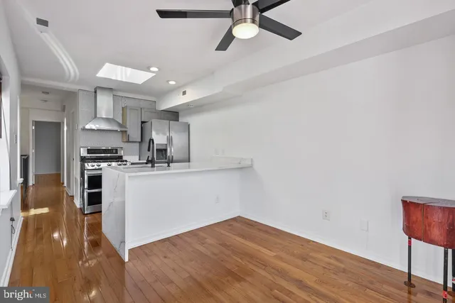 a kitchen with a refrigerator and white cabinets