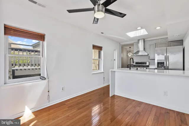 a view of a kitchen with a sink wooden floor and a window