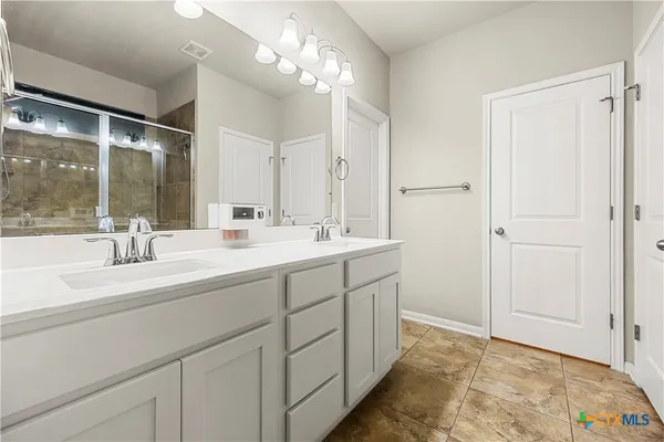 a bathroom with a sink double vanity and a mirror
