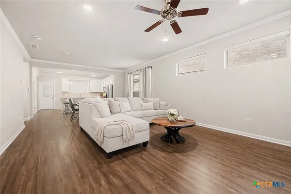 a living room with furniture and a wooden floor