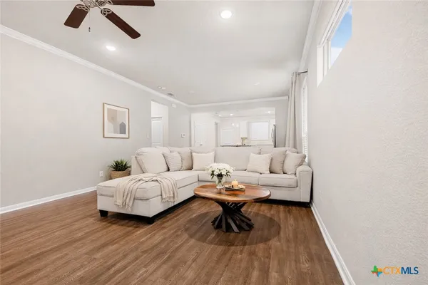a living room with furniture and a wooden floor