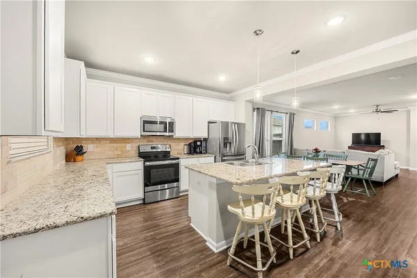 a large kitchen with a table and chairs