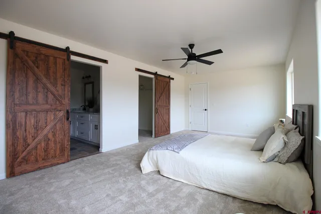 a bedroom with a bed and a ceiling fan