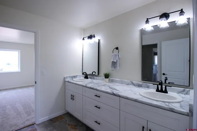 a bathroom with a granite countertop sink double and mirror