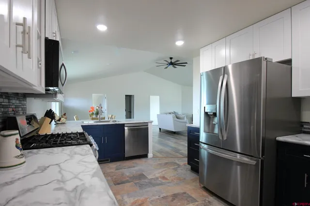 a kitchen with stainless steel appliances granite countertop a refrigerator sink and stove