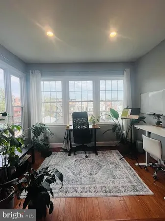 a living room with furniture a piano and a potted plant
