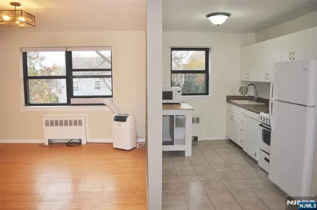 a kitchen with white cabinets and window