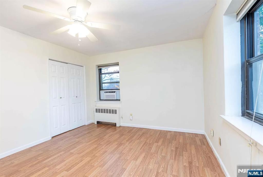 130 Orient Way, Unit 3D Rutherford, NJ 07070 - Photo 15 of 22 an empty room with wooden floor chandelier fan and windows