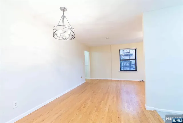 a view of a room with wooden floor and white walls