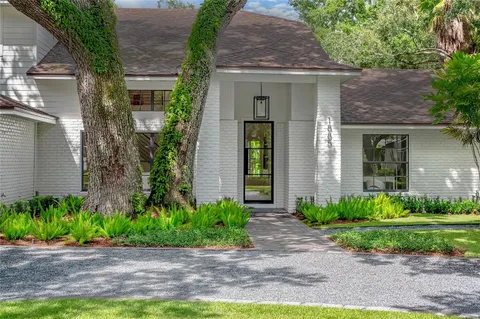 a front view of a house with a yard and potted plants