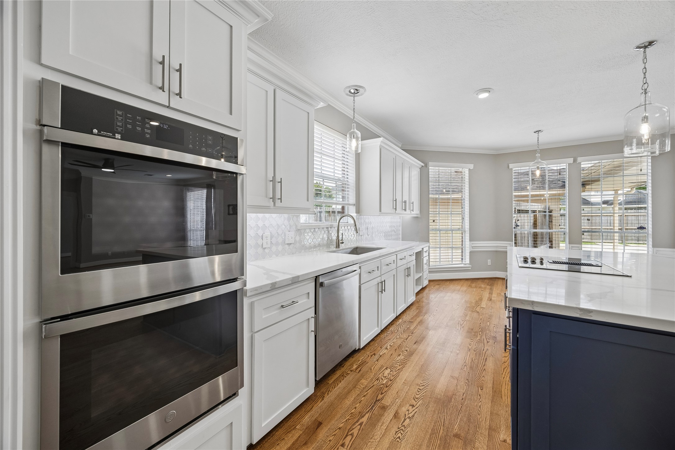 7915 Huddersfield Court Spring, TX 77379 - Photo 18 of 37 Updated kitchen with stainless steel appliances, double ovens, ample cabinetry, modern backsplash, and a bright breakfast area overlooking the backyard.