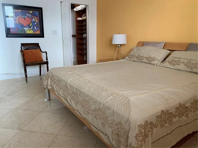 a bedroom with a bed and a potted plant on it