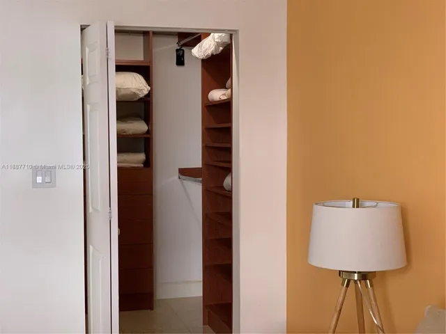 a view of a hallway with wooden floor and cabinets