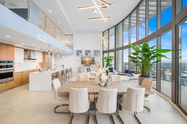 a dining room with furniture a floor to ceiling window and wooden floor