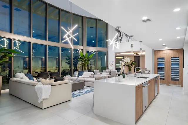 a living room with furniture a large window and kitchen view