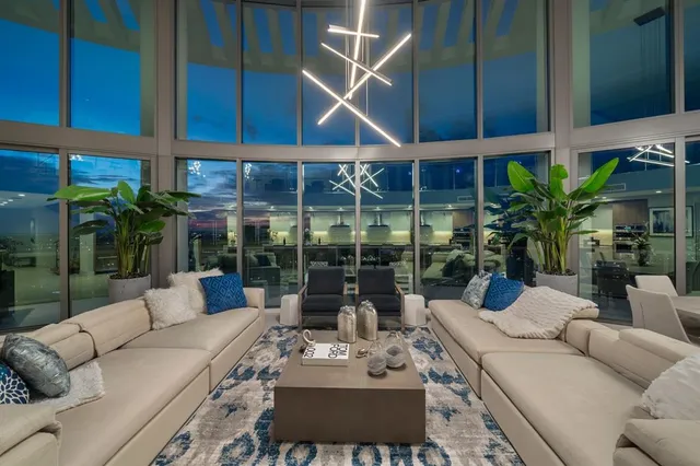 a view of a patio with couches table and chairs potted plants and palm tree