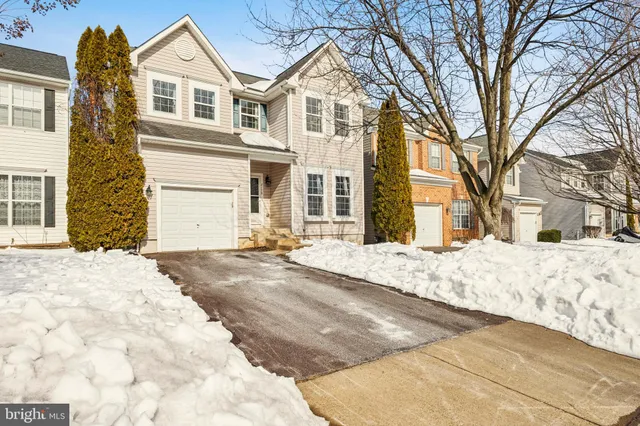 a front view of a house with a yard covered in snow