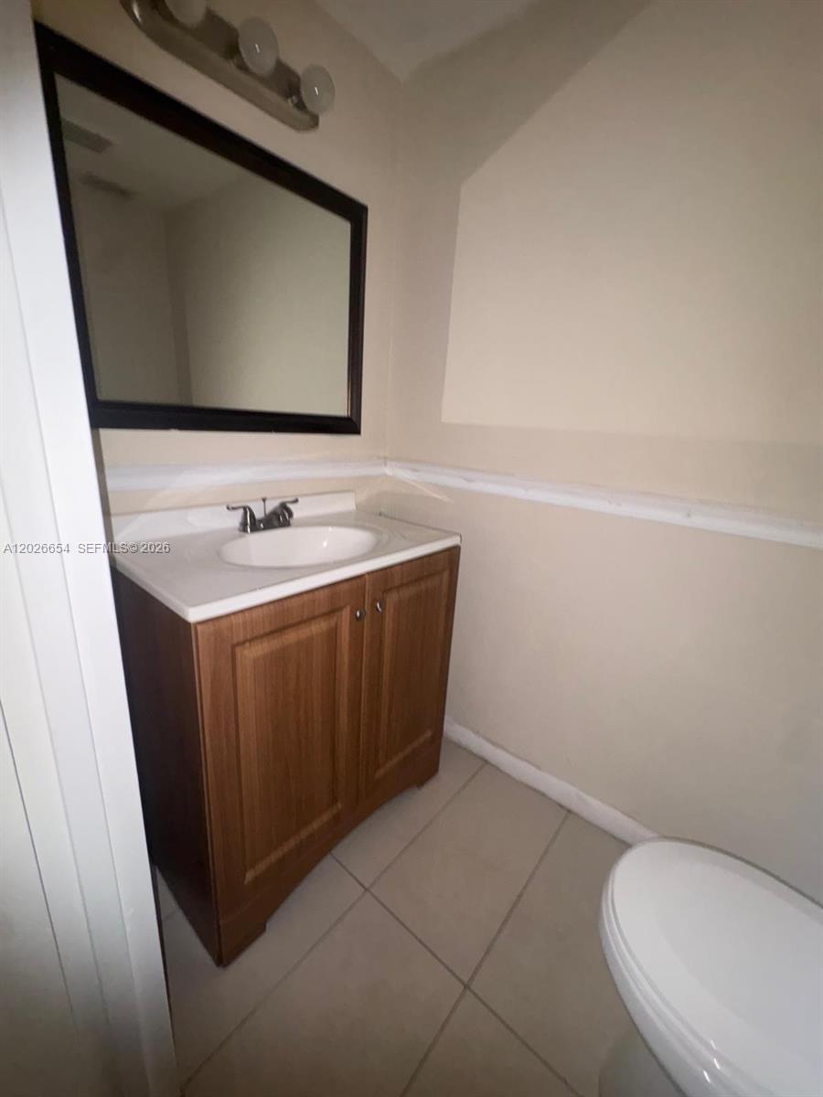 4174 Inverrary Drive, Unit 903 Lauderhill, FL 33319 - Photo 30 of 36 a bathroom with a toilet sink and mirror
