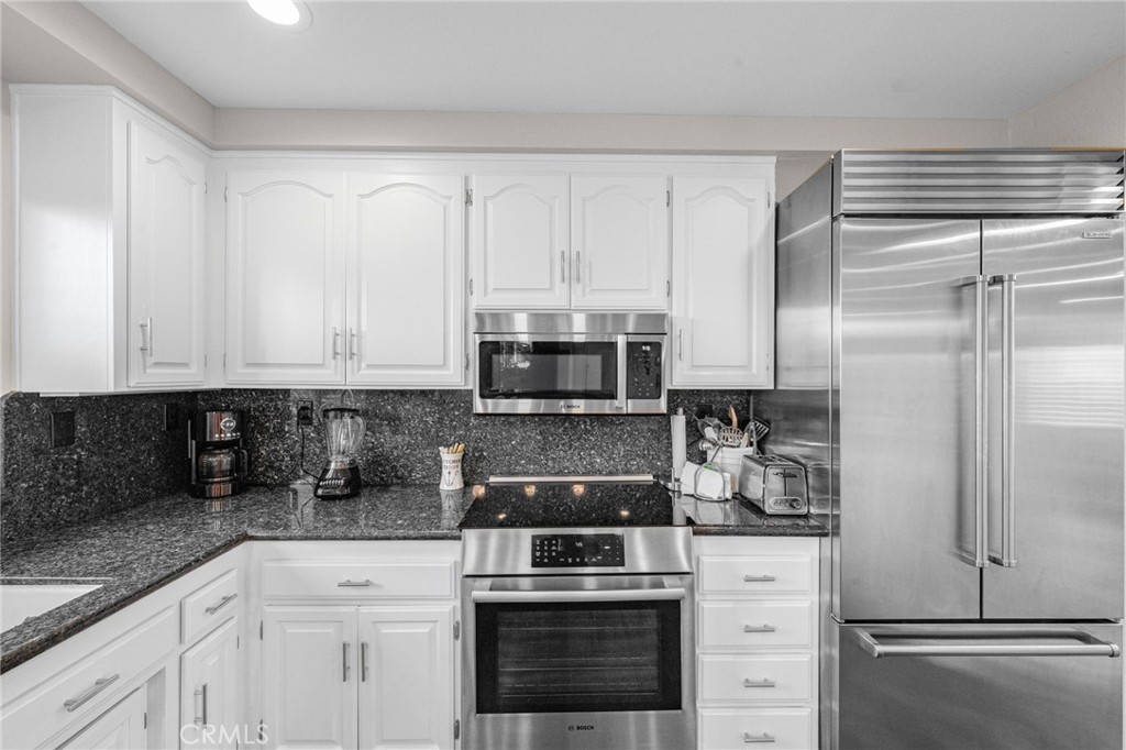 40337 Carmelita Circle Temecula, CA 92591 - Photo 13 of 65 a kitchen with white cabinets and white appliances