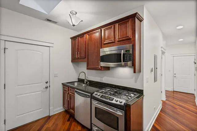 a kitchen with stainless steel appliances granite countertop a stove and a refrigerator