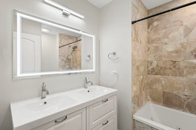 a bathroom with a sink mirror and a bathtub