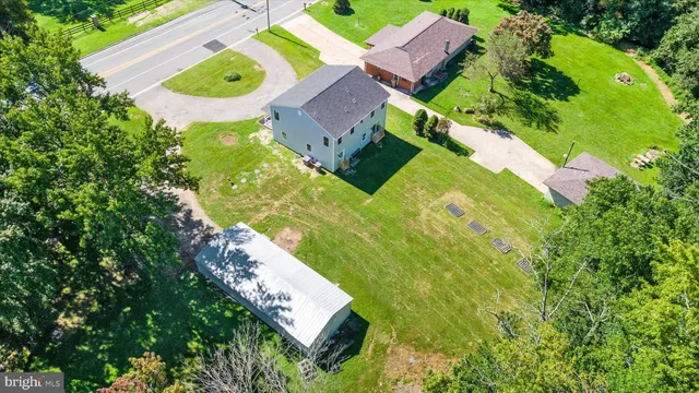 an aerial view of residential house with outdoor space and trees all around