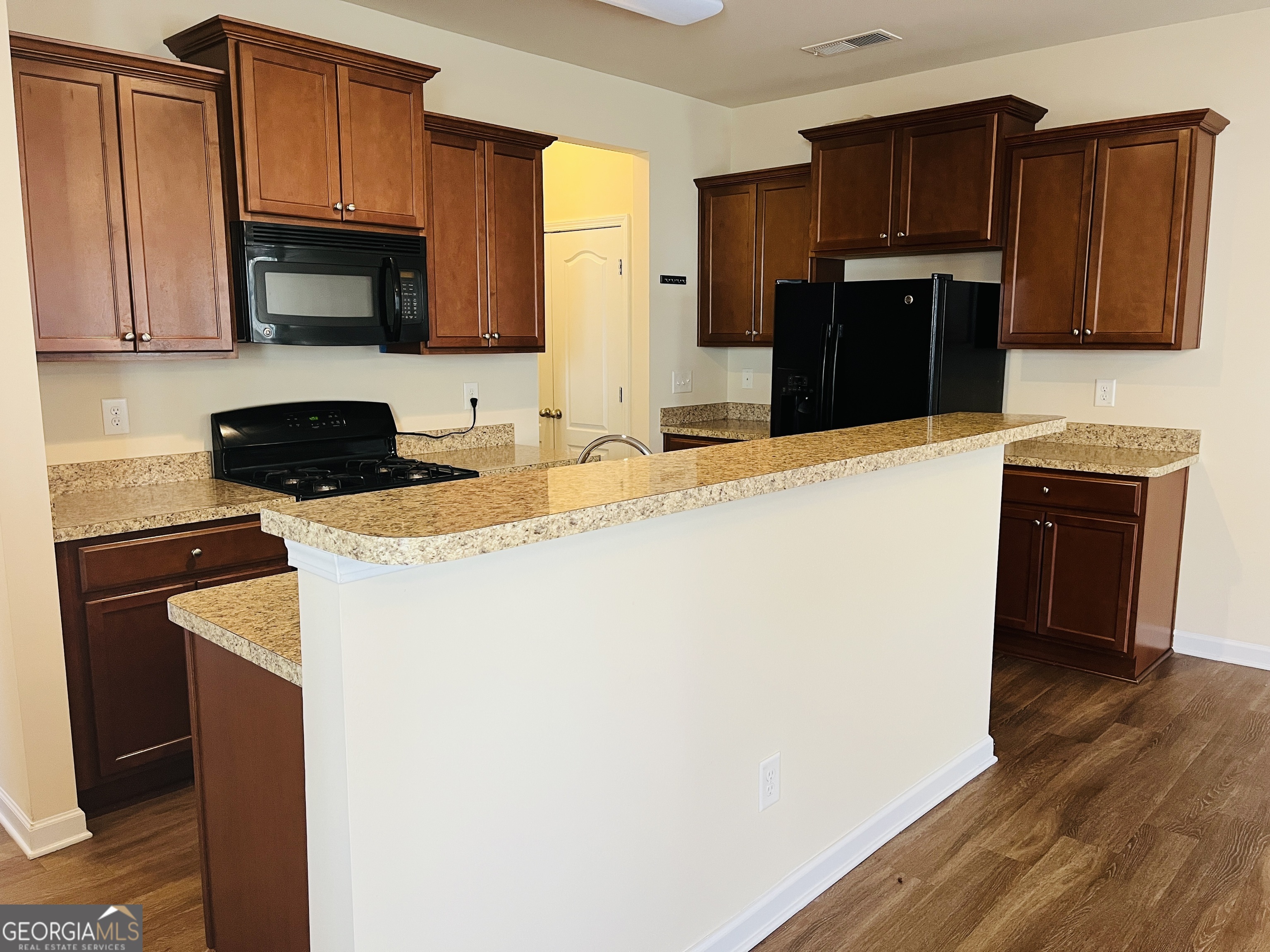 233 Bobbie Way Woodstock, GA 30189 - Photo 4 of 32 a kitchen with granite countertop a refrigerator stove and microwave