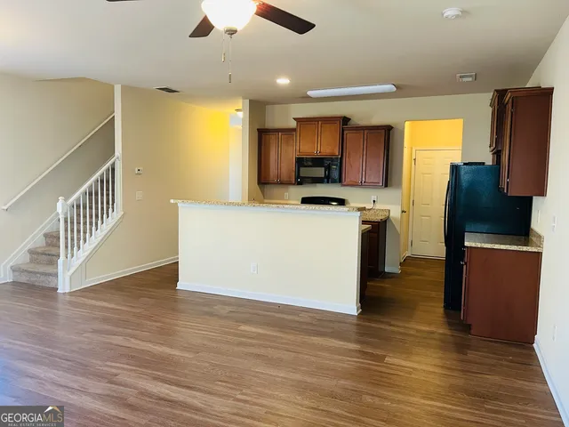a view of kitchen with microwave refrigerator and cabinets