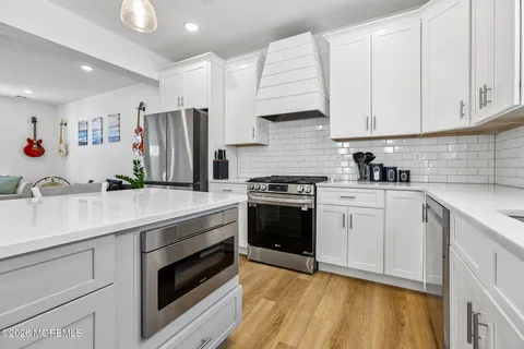 a kitchen with granite countertop a sink stainless steel appliances and cabinets