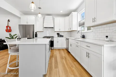 a kitchen with a sink a refrigerator and cabinets