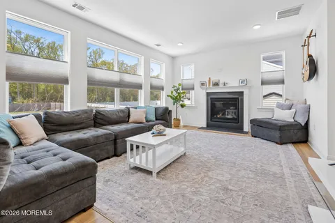 a living room with furniture a large window and a fireplace