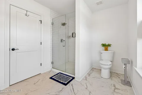a bathroom with a toilet and a shower