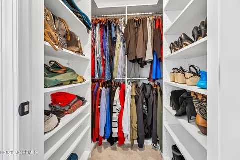 a view of walk in closet with clothes and shoes