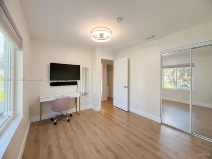 a view of a livingroom with wooden floor and a flat screen tv