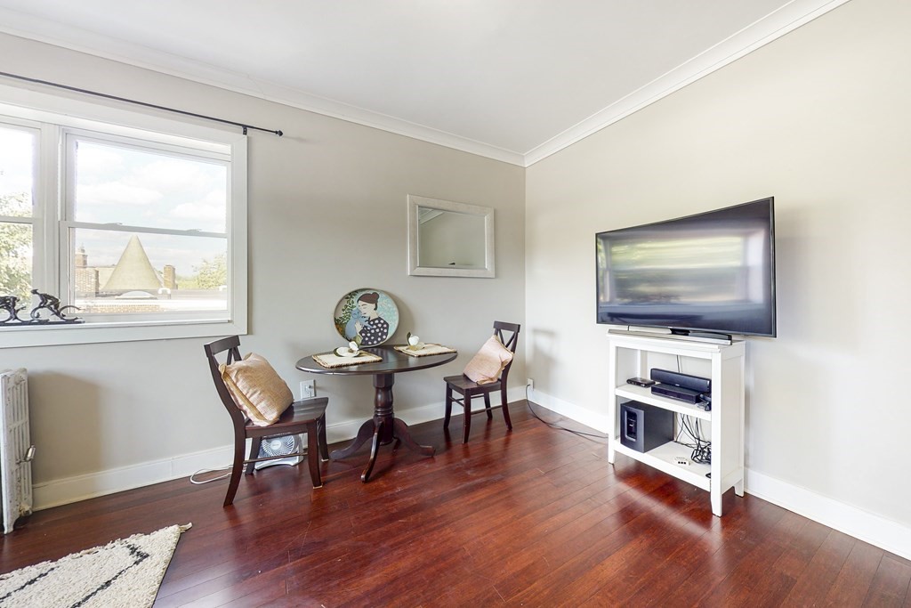 1834 Beacon Street, Unit 16 Brookline, MA 02445 - Photo 11 of 21 a living room with furniture flat screen tv and wooden floor