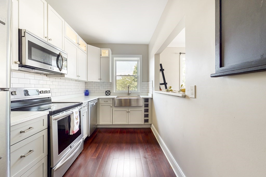 1834 Beacon Street, Unit 16 Brookline, MA 02445 - Photo 14 of 21 a kitchen with a sink stove and cabinets