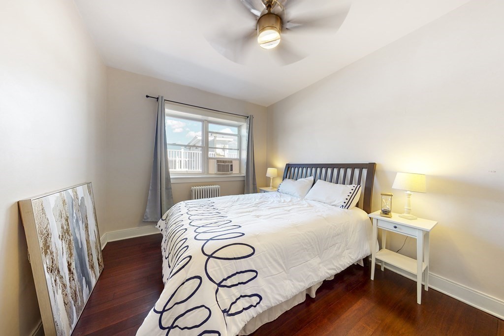 1834 Beacon Street, Unit 16 Brookline, MA 02445 - Photo 4 of 21 a bedroom with a bed and wooden floor