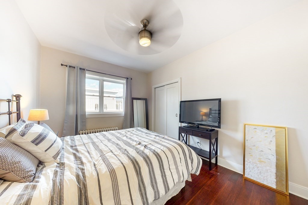 1834 Beacon Street, Unit 16 Brookline, MA 02445 - Photo 9 of 21 a bedroom with a bed and a flat tv screen on dresser