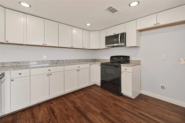 a kitchen with granite countertop white cabinets and white appliances