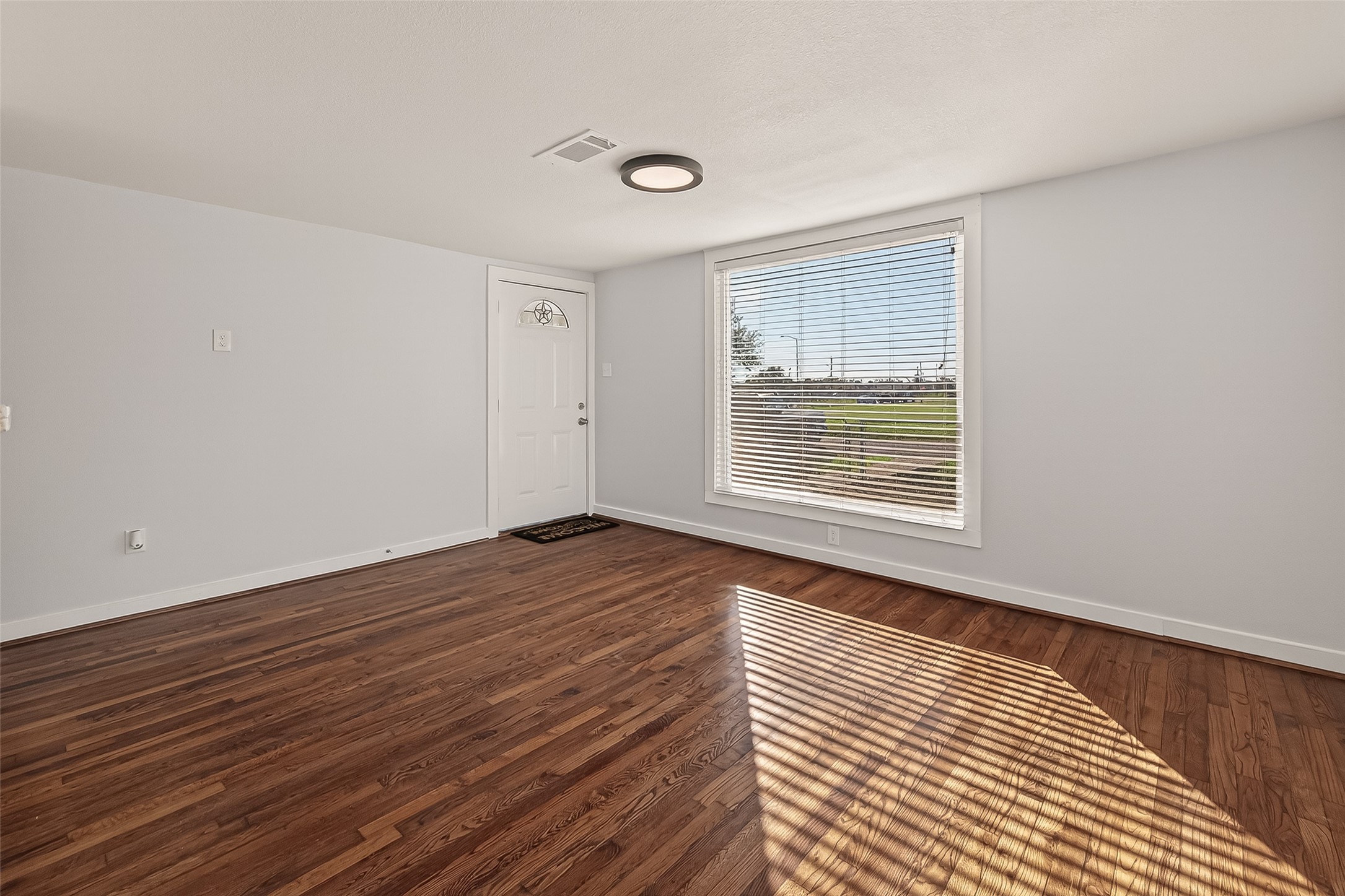 754 Prosper Street Houston, TX 77088 - Photo 6 of 28 a view of an empty room with wooden floor and a window