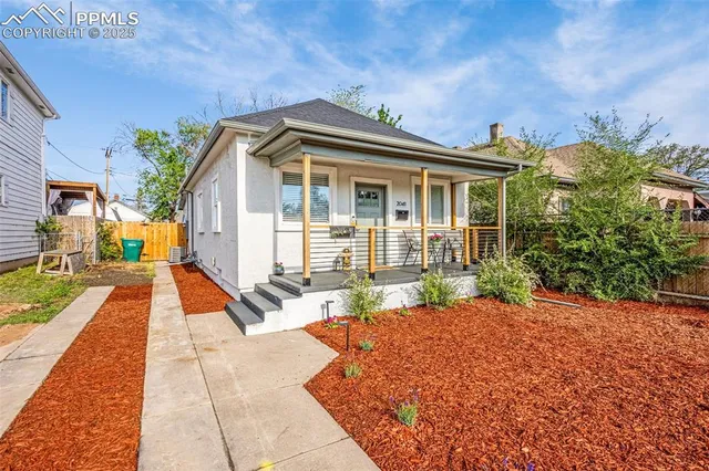 a view of a house with backyard and sitting area