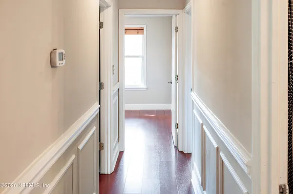 a view of a hallway with wooden floor and staircase