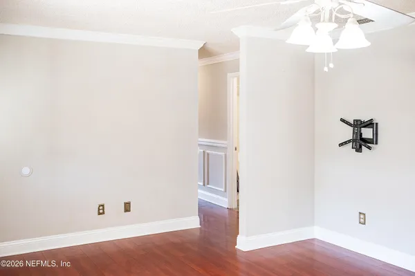 a view of an empty room with wooden floor