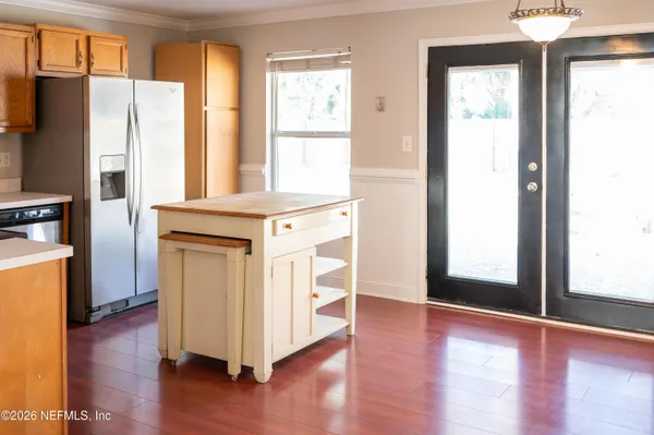 a view of a kitchen with wooden floor and a large window
