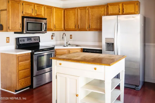 a kitchen with stainless steel appliances granite countertop a stove a microwave and a refrigerator